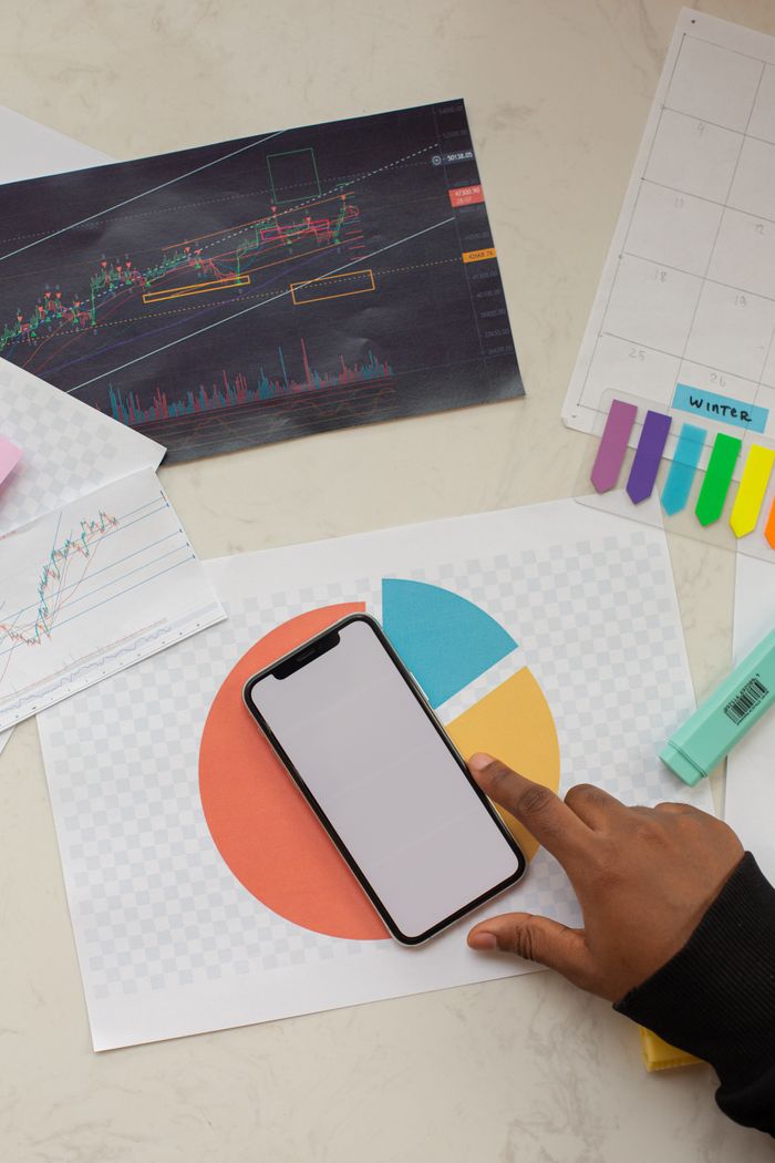 Creative business workspace featuring a smartphone mockup and financial charts.